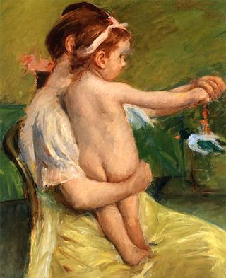 Mother Holding a Nude Baby Playing with a Toy Duck
