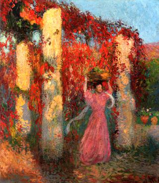 Jeune femme portant une corbeille sur la tête devant une pergola de vigne-verge rouge