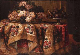 Grapes in a basket with sweetmeats on a salver on a draped table